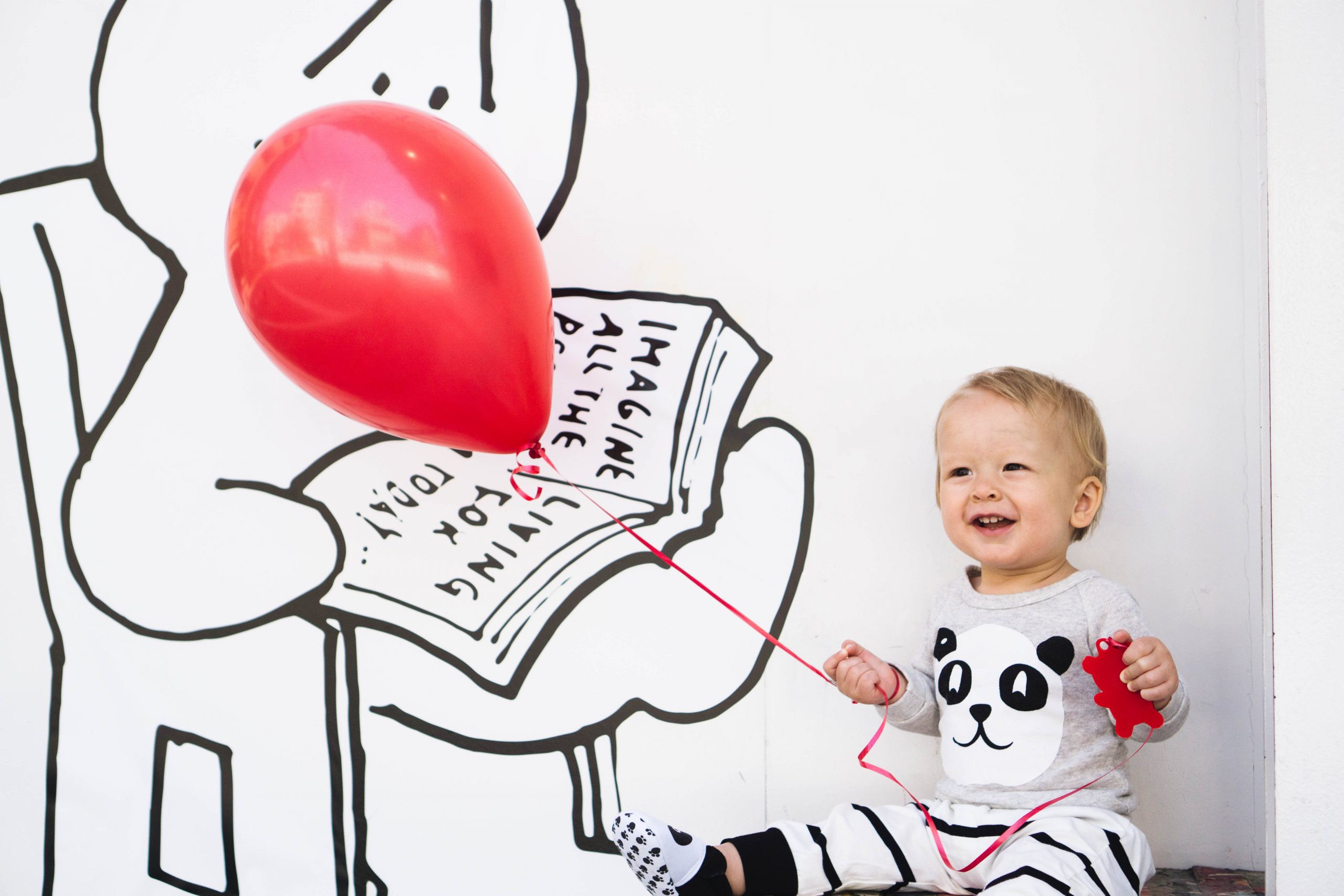 Bébé jouant avec un ballon rouge dans une crèche