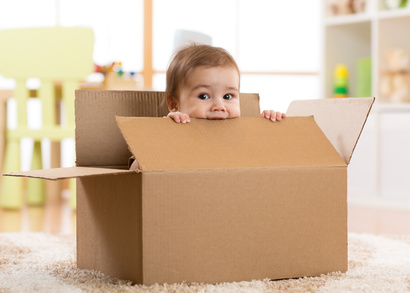Bébé qui se cache dans un carton de déménagement