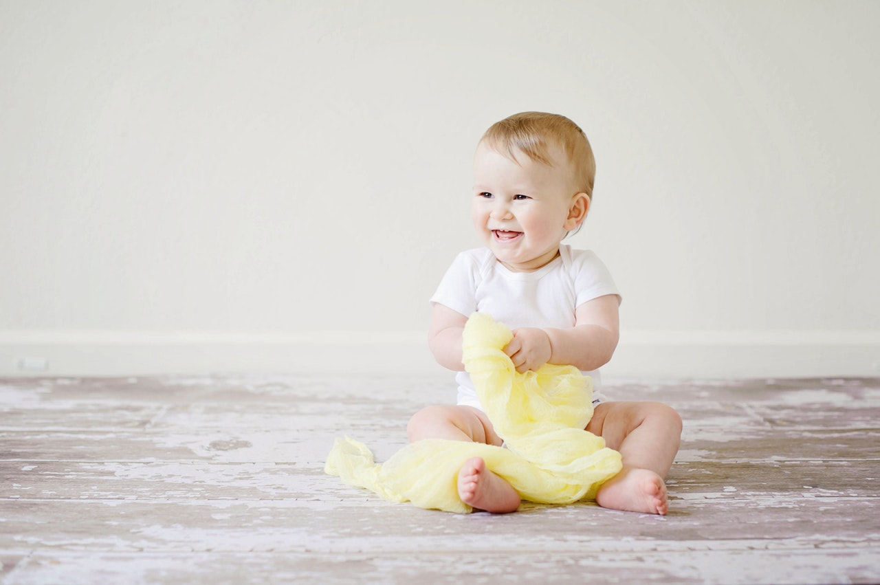 Bébé qui tient du tissu jaune